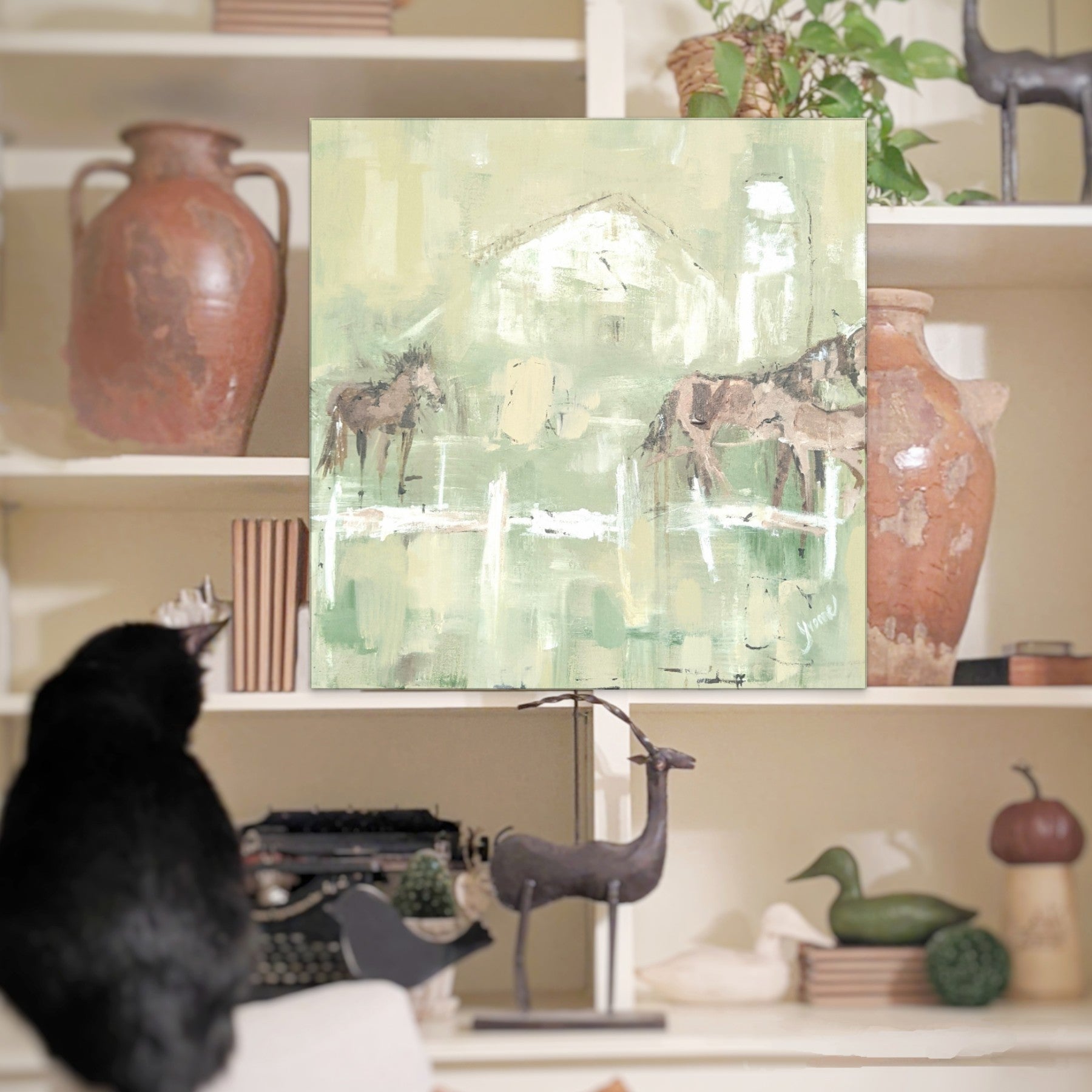Barn cat admires horse art in farmhouse living room 